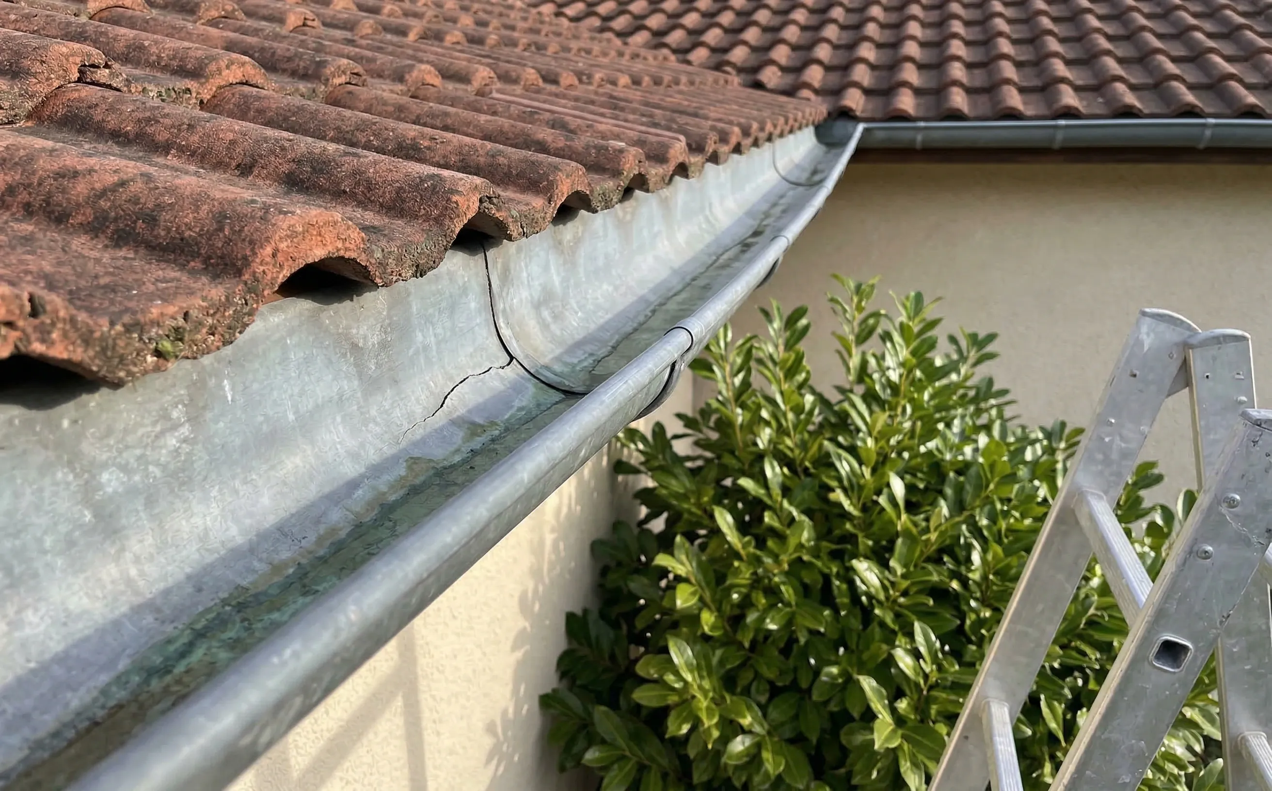 Gouttière en zinc fissurée le long d'un pli sur un pavillon girondin des années 1980