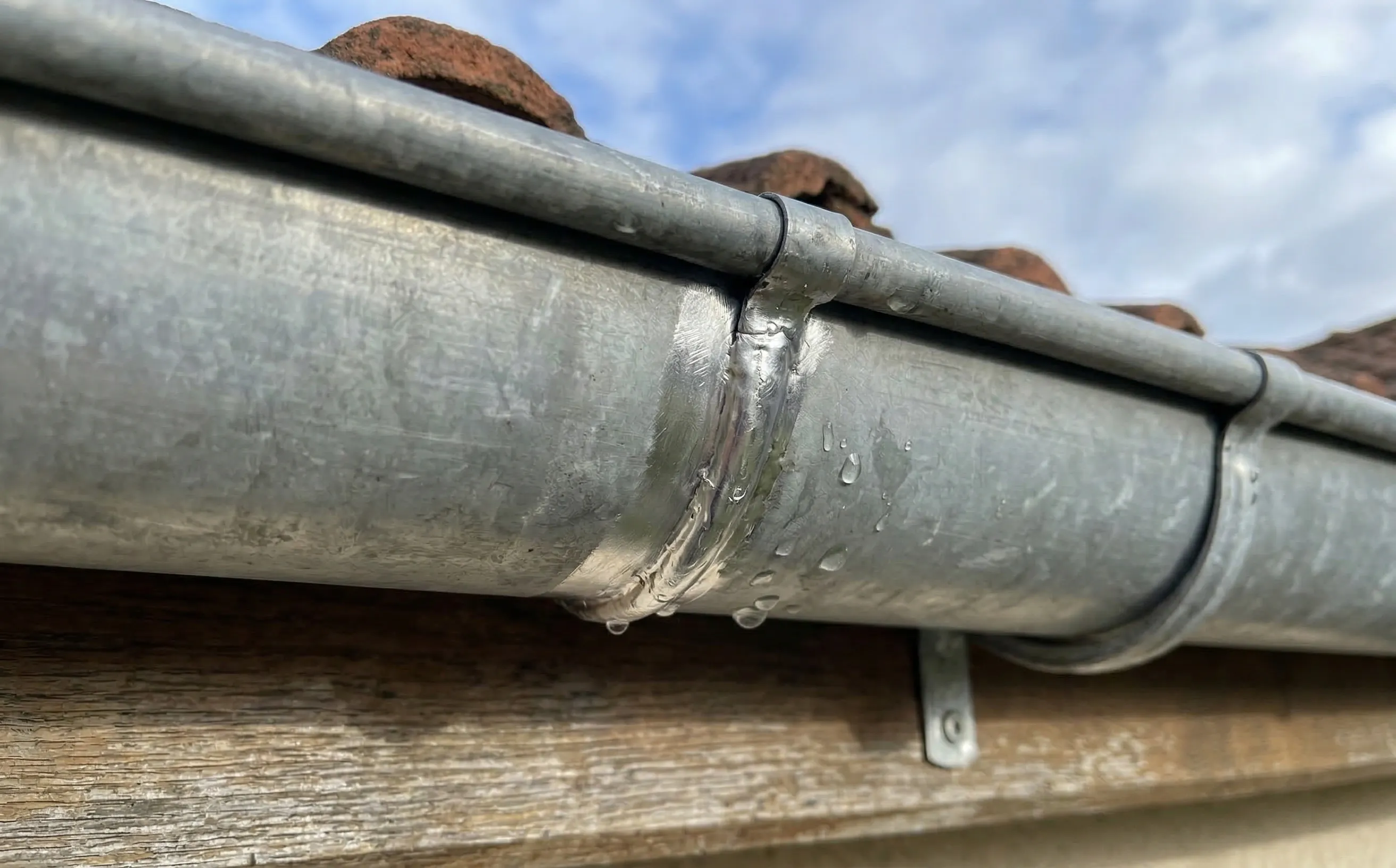 Jonction de deux éléments de gouttière zinc avec talon de recouvrement soudé à l'étain neuf